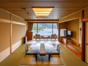 萩市にある萩観光ホテルのテーブルと椅子、大きな窓が備わる客室です。