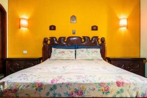 a bedroom with a large bed with a floral bedspread at Suítes Casa Verde in Arraial do Cabo +47 photos