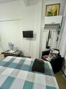 um pequeno quarto com uma cama e uma cadeira em Studio no Largo da Carioca - Rio de Janeiro no Rio de Janeiro