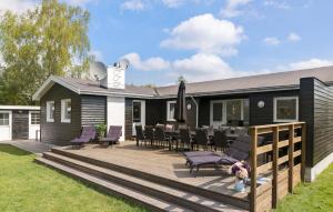 una casa con terraza con mesa y sillas en 6 Bedroom Awesome Home In Væggerløse, en Bøtø By 14 fotos más