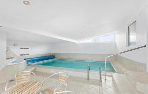 una piscina con 2 sillas y una bañera en 6 Bedroom Awesome Home In Væggerløse, en Bøtø By