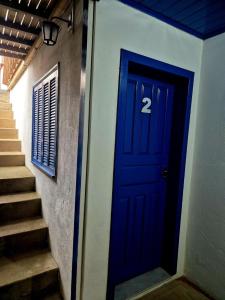 - une porte bleue avec le numéro 2 à côté des escaliers dans l'établissement Pousada central Vino e Leta, à Grão Pará