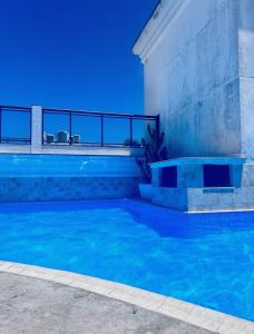 a swimming pool with blue lights on the side of a building at Loft Prainha in Arraial do Cabo