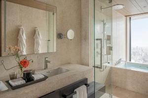 a bathroom with a sink and a shower and a tub at Four Seasons Hotel Osaka in Osaka