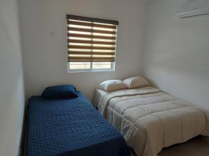 2 łóżka w białym pokoju z oknem w obiekcie Alojamiento Entero Monterrey Airport w mieście Monterrey