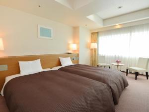 una camera da letto con un letto grande e una grande finestra di Nagoya Creston Hotel a Nagoya
