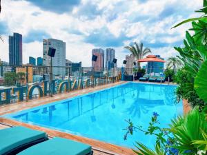 a swimming pool on the roof of a building with a city skyline at Happy Life Grand Hotel & Sky Bar in Ho Chi Minh City