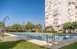 a swimming pool in front of a tall building at Gorgeous Apartment In Mlaga With House Sea View in Málaga