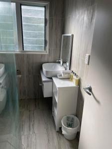 a bathroom with a sink and a toilet and a mirror at Hawaiki Villas in Rarotonga