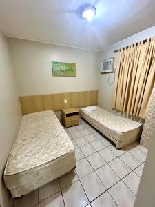 a room with two beds in it with a window w obiekcie Ap 106 Sol das Caldas w mieście Caldas Novas
