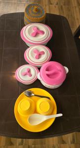 a table with pink and yellow plates and spoons at TREE HOUSE BY THE CITY ESCAPE in Shimla