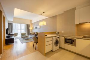 a kitchen and living room with a dishwasher at CM Service Apartment Tianjin in Tianjin
