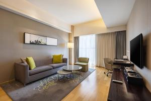 a living room with a couch and a television at CM Service Apartment Tianjin in Tianjin