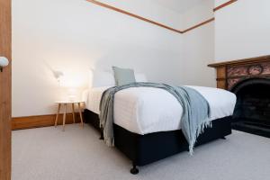 - une chambre avec un grand lit et une cheminée dans l'établissement Timeless Elegance with City Views Wi-Fi & Parking, à Launceston