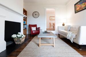 un salon avec un canapé blanc et une table basse dans l'établissement Timeless Elegance with City Views Wi-Fi & Parking, à Launceston