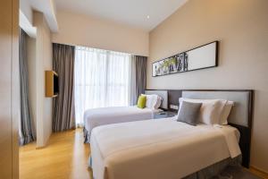 Habitación de hotel con 2 camas y TV en CM Service Apartment Tianjin en Tianjin