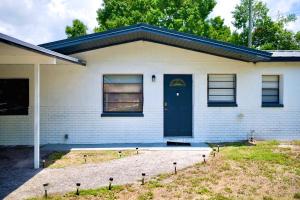 una casa de ladrillo blanco con puerta azul en Stunning Modern Home in Tampa with Pool - Just 5 Minutes from Airport!, en Tampa