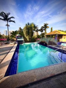 duży basen z niebieską wodą i palmami w obiekcie Ap 106 Sol das Caldas w mieście Caldas Novas
