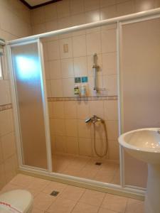 W łazience znajduje się prysznic ze szklanymi drzwiami. w obiekcie Yun Meng Xianjing Homestay w mieście Ren’ai