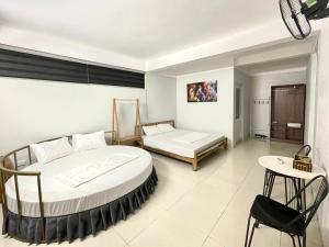 1 Schlafzimmer mit 2 Betten, einem Tisch und einem Stuhl in der Unterkunft Hotel Me Kong 2 in Hạ Long