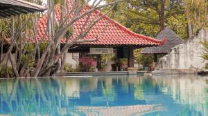 a swimming pool in front of a building at Lorin Dwangsa Solo Hotel in Solo