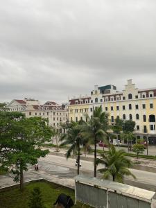um grande edifício com palmeiras em frente a uma rua em Hotel Me Kong 2 em Ha Long