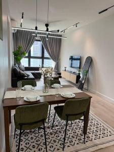 ein Wohnzimmer mit einem Holztisch und Stühlen in der Unterkunft M Vertica Residence in Kuala Lumpur