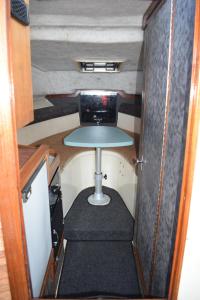 Una pequeña habitación con una mesa y una mesa en un remolque. en Stamas Yacht Varna, en Varna