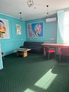 - un salon avec une table et un canapé dans l'établissement All Eyes Hostel, à Kamianets-Podilsky