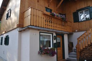 a house with a balcony and flowers on it at CiasaToa in Cortina dʼAmpezzo