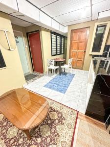 uma sala de estar com uma mesa e uma porta em Dusun Indah Cottage 3 em Bayan Lepas