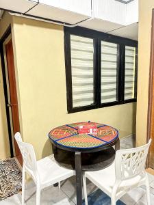 mesa y sillas en una habitación con mesa en Dusun Indah Cottage 3 en Bayan Lepas