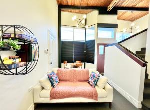 ein Wohnzimmer mit einem Sofa und einer Treppe in der Unterkunft Opoho Heritage Guest Suite in Dunedin