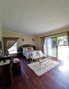 a bedroom with a bed and a couch and a table at Exclusive Private Room in Joburg No loadshedding in Johannesburg
