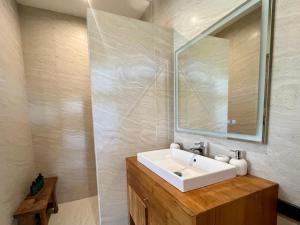 uma casa de banho com um lavatório branco e um espelho. em Moorea Boutique Resort Samui em Koh Samui