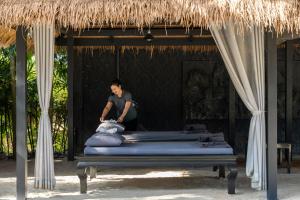チャン島にあるThe Splash Koh Changのリゾート内のベッドの横に立つ男
