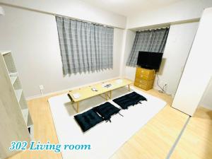 uma sala de estar com uma mesa e uma televisão em Mcity in WAKASA - Vacation STAY 84253v em Naha