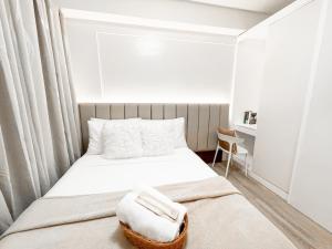 1 dormitorio pequeño con 1 cama y 1 silla en AZRA Bacolod at Mesavirre Garden Residences en Bacolod