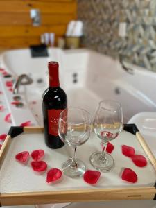 a tray with two glasses and a bottle of wine at Cabanas Rural Colina Do Sol in Cambará