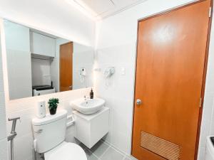 a bathroom with a toilet and a sink at AZRA Bacolod at Mesavirre Garden Residences in Bacolod