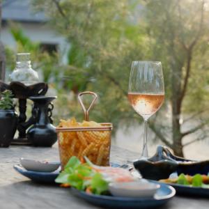 un verre de vin assis sur une table avec de la nourriture dans l'établissement Moorea Boutique Resort Samui, à Koh Samui 