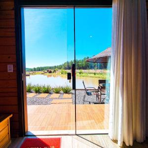 a sliding glass door to a patio with a view of a lake at Cabanas Rural Colina Do Sol in Cambará