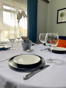 einen Tisch mit Tellern und Weingläsern darauf in der Unterkunft Beautiful apartment in Guildford with parking in Send