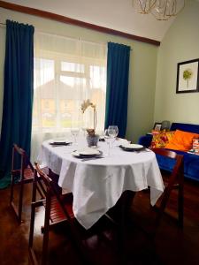 uma mesa com uma toalha de mesa branca e copos de vinho em Beautiful apartment in Guildford with parking em Send