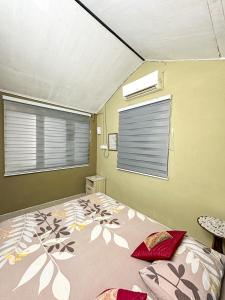 ein Schlafzimmer mit großem Bett und Fenster in der Unterkunft Dusun Indah Cottage 3 in Bayan Lepas