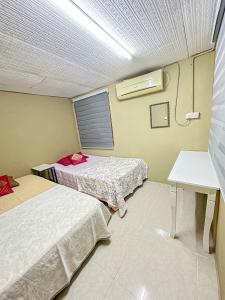 Cette chambre comprend 2 lits et une fenêtre. dans l'établissement Dusun Indah Cottage 3, à Bayan Lepas