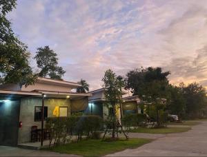 a house with a cloudy sky in front of it at พิเศษรีสอร์ท อุตรดิตถ์ Piset Resort in Ban Ko Mamuang