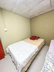 um pequeno quarto com duas camas em Dusun Indah Cottage 3 em Bayan Lepas