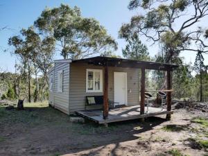 a tiny house in the bush with a porch at La Casita in Cooma