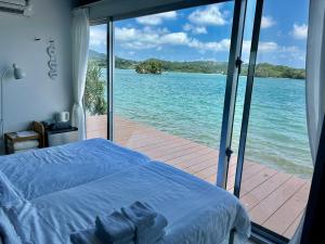 a bedroom with a bed and a view of the ocean at Nel Beach in Nago